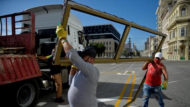 Workers protect windows and glass doors by dismantling them from the Paseo del Prado Hotel during preparations for the arrival of tropical storm Laura in Havana on August 24. Once Laura moves into the warm Gulf of Mexico that serves as fuel for storms, forecasters predict it will rapidly strengthen to hurricane status ahead of an expected August 26 landfall. (Yamil Lage / AFP)