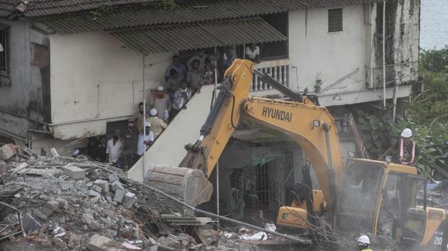 Local residents watch as rescue personnel dig through the rubble operation in Mahad on August 25. According to Raigad District Superintendent of Police Anil Paraskar, a First information Report (FIR) was registered on August 25 at Mahad city police station against the builder and four others: architect, RCC consultant and two civic officials. No arrests have been made till now, HT reported. (Pratham Gokhale / HT Photo) Local residents watch as rescue personnel dig through the rubble operation in Mahad on August 25. According to Raigad District Superintendent of Police Anil Paraskar, a First information Report (FIR) was registered on August 25 at Mahad city police station against the builder and four others: architect, RCC consultant and two civic officials. No arrests have been made till now, HT reported. (Pratham Gokhale / HT Photo)