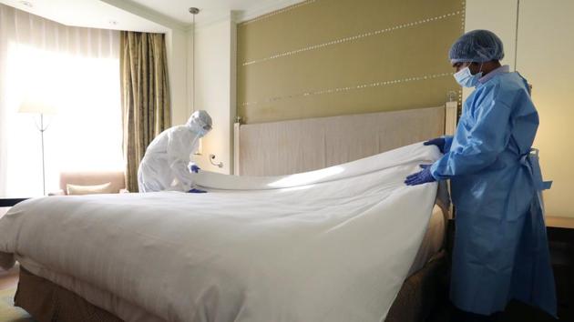 Employees wearing personal protective equipment (PPE) make a bed inside a room at the ITC Maurya Sheraton Hotel ahead of its reopening in New Delhi on August 22 as the country moved towards the next phase of unlock guidelines expected to come into effect from September 1. (T. Narayan / Bloomberg) Employees wearing personal protective equipment (PPE) make a bed inside a room at the ITC Maurya Sheraton Hotel ahead of its reopening in New Delhi on August 22 as the country moved towards the next phase of unlock guidelines expected to come into effect from September 1. (T. Narayan / Bloomberg)