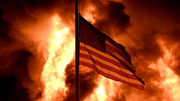 Flames engulf the Community Corrections Division building as an American flag flutters on a pole as protests turn to fires after a Black man, identified as Jacob Blake, was shot several times by police last night in Kenosha, Wisconsin, US on August 24, 2020. (Reuters File Photo) Flames engulf the Community Corrections Division building as an American flag flutters on a pole as protests turn to fires after a Black man, identified as Jacob Blake, was shot several times by police last night in Kenosha, Wisconsin, US on August 24, 2020. (Reuters File Photo)