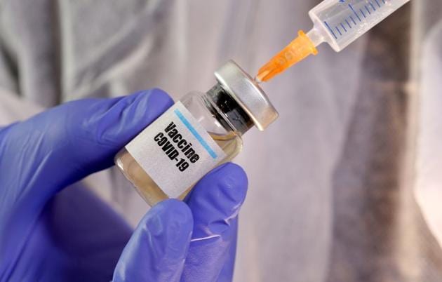 FILE PHOTO: A woman holds a small bottle labeled with a "Vaccine COVID-19" sticker and a medical syringe in this illustration taken April 10, 2020.(REUTERS)