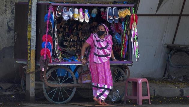 A woman wearing a face mask waits for customers while selling sandals at a street stall in Hyderabad on August 24. The health ministry in a tweet on August 24 attributed the widening gap to “effective implementation of Centre-led policies ensuring efficient clinical management in hospital settings for critical patients, and supervised home Isolation for moderate and mild ones.” (Mahesh Kumar A. / AP) A woman wearing a face mask waits for customers while selling sandals at a street stall in Hyderabad on August 24. The health ministry in a tweet on August 24 attributed the widening gap to “effective implementation of Centre-led policies ensuring efficient clinical management in hospital settings for critical patients, and supervised home Isolation for moderate and mild ones.” (Mahesh Kumar A. / AP)