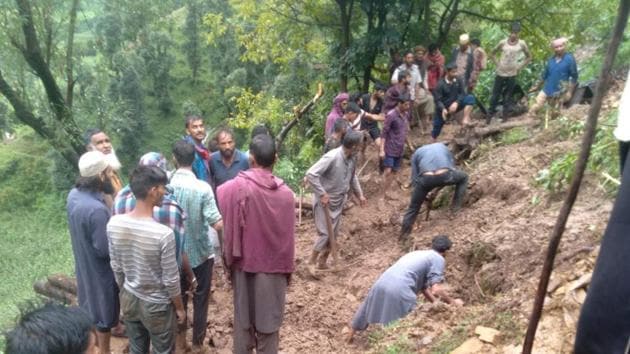 Locals in Mendhar in Poonch carry out a rescue operation after a cattle shed collapsed in heavy rain.(HT PHOTO)