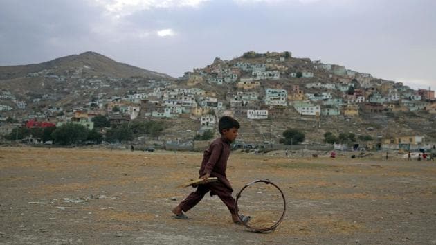 An Afghan boy pushes a wheel on the outskirts of Kabul, Afghanistan.(AP) An Afghan boy pushes a wheel on the outskirts of Kabul, Afghanistan.(AP)