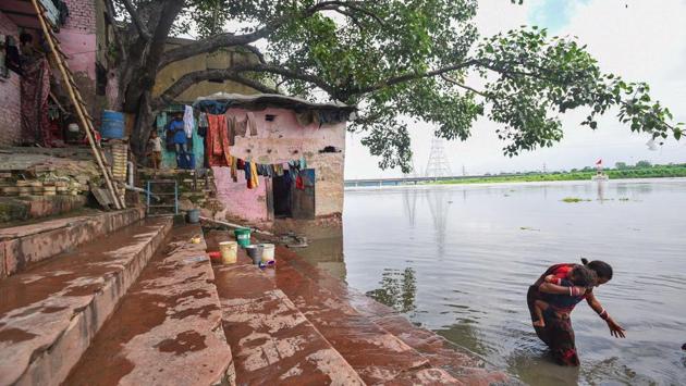 A mother bathes her child in the waters of Yamuna at Nigambodh Ghat in New Delhi on August 25. Officials in the Delhi government’s Irrigation and Flood Control (I&FC) Department told HT that the level recorded on August 26, i.e. 203.78 metres, was below the warning mark at present and is unlikely to rise unless a large amount of water is released from the Hathnikund barrage. (Biplov Bhuyan / HT Photo)
