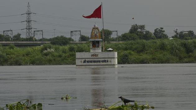 A temple by the banks of the river Yamuna is partially submerged as water levels rise at Nigambodh Ghat in New Delhi on August 25. According to Sanjeev Kumar, officer-in-charge, Flood Control there are many factors responsible for the surge in Yamuna. “During the monsoon, because of the higher volume of water in the barrage coupled with rainfall in the hilly regions, more water is released,” he told HT. (Biplov Bhuyan / HT Photo)