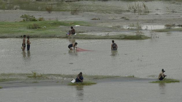 People fishing by the banks of Yamuna near the Signature Bridge in New Delhi on August 25. This water released high up the altitude typically takes about 36 to 72 hours to reach Delhi. (Biplov Bhuyan / HT Photo)
