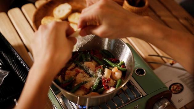Lee Seung-yoon cooks on a portable stove inside his house in Seoul. According to Reuters, the family is now on their second weekend home-camping trip. On August 22, they cooked gambas al ajillo, a Spanish garlic shrimp dish, and pasta on a portable stove while it rained outside. (Kim Hong-Ji / REUTERS)