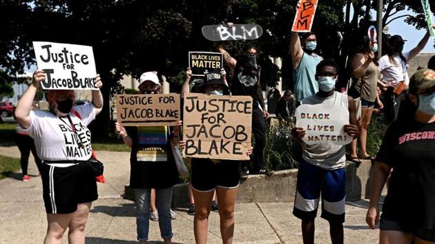 People hold placards as they gather for a protest outside the Kenosha County Courthouse after a Black man, identified as Jacob Blake, was shot several times by police last night in Kenosha, Wisconsin, US on August 24, 2020. (Reuters Photo) People hold placards as they gather for a protest outside the Kenosha County Courthouse after a Black man, identified as Jacob Blake, was shot several times by police last night in Kenosha, Wisconsin, US on August 24, 2020. (Reuters Photo)