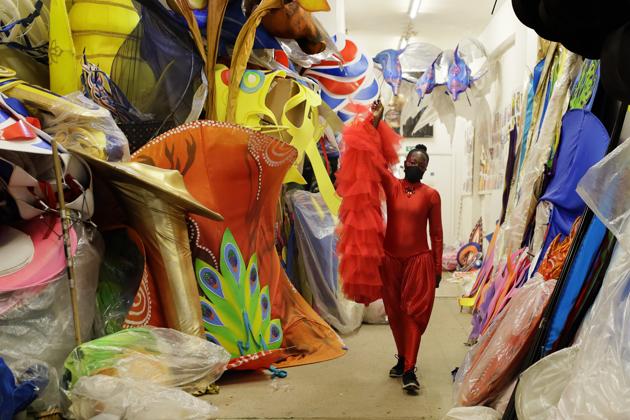 Ebony Beckford carries part of her costume as she gets ready for a prepping event ahead of this year's Notting Hill Carnival which will be held virtually, in London, Thursday, Aug. 20, 2020. London's Notting Hill Carnival traces its roots to the emancipation of Black slaves and race riots in the city during the late 1950s. Organizers say the event is more important than ever amid the worldwide campaign for justice following the death of George Floyd in police custody. But their message of resistance and reconciliation will be delivered online worldwide this weekend after the COVID-19 pandemic forced the party to reinvent itself as a virtual event. (AP Photo/Kirsty Wigglesworth) (AP) Ebony Beckford carries part of her costume as she gets ready for a prepping event ahead of this year's Notting Hill Carnival which will be held virtually, in London, Thursday, Aug. 20, 2020. London's Notting Hill Carnival traces its roots to the emancipation of Black slaves and race riots in the city during the late 1950s. Organizers say the event is more important than ever amid the worldwide campaign for justice following the death of George Floyd in police custody. But their message of resistance and reconciliation will be delivered online worldwide this weekend after the COVID-19 pandemic forced the party to reinvent itself as a virtual event. (AP Photo/Kirsty Wigglesworth) (AP)