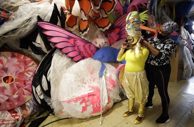 Anucska Case assists Carolyn Roberts-Griffith with her costume for a prepping event ahead of this year's Notting Hill Carnival which will be held virtually, in London, Thursday, Aug. 20, 2020. London's Notting Hill Carnival traces its roots to the emancipation of Black slaves and race riots in the city during the late 1950s. Organizers say the event is more important than ever amid the worldwide campaign for justice following the death of George Floyd in police custody. But their message of resistance and reconciliation will be delivered online worldwide this weekend after the COVID-19 pandemic forced the party to reinvent itself as a virtual event. (AP Photo/Kirsty Wigglesworth) (AP) Anucska Case assists Carolyn Roberts-Griffith with her costume for a prepping event ahead of this year's Notting Hill Carnival which will be held virtually, in London, Thursday, Aug. 20, 2020. London's Notting Hill Carnival traces its roots to the emancipation of Black slaves and race riots in the city during the late 1950s. Organizers say the event is more important than ever amid the worldwide campaign for justice following the death of George Floyd in police custody. But their message of resistance and reconciliation will be delivered online worldwide this weekend after the COVID-19 pandemic forced the party to reinvent itself as a virtual event. (AP Photo/Kirsty Wigglesworth) (AP)