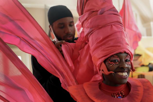 Jez Smith helps Ebony Beckford to get her costume ready for a prepping event ahead of this years Notting Hill Carnival which will be held virtually, in London, Thursday, Aug. 20, 2020. London's Notting Hill Carnival traces its roots to the emancipation of Black slaves and race riots in the city during the late 1950s. Organizers say the event is more important than ever amid the worldwide campaign for justice following the death of George Floyd in police custody. But their message of resistance and reconciliation will be delivered online worldwide this weekend after the COVID-19 pandemic forced the party to reinvent itself as a virtual event. (AP Photo/Kirsty Wigglesworth) (AP) Jez Smith helps Ebony Beckford to get her costume ready for a prepping event ahead of this years Notting Hill Carnival which will be held virtually, in London, Thursday, Aug. 20, 2020. London's Notting Hill Carnival traces its roots to the emancipation of Black slaves and race riots in the city during the late 1950s. Organizers say the event is more important than ever amid the worldwide campaign for justice following the death of George Floyd in police custody. But their message of resistance and reconciliation will be delivered online worldwide this weekend after the COVID-19 pandemic forced the party to reinvent itself as a virtual event. (AP Photo/Kirsty Wigglesworth) (AP)