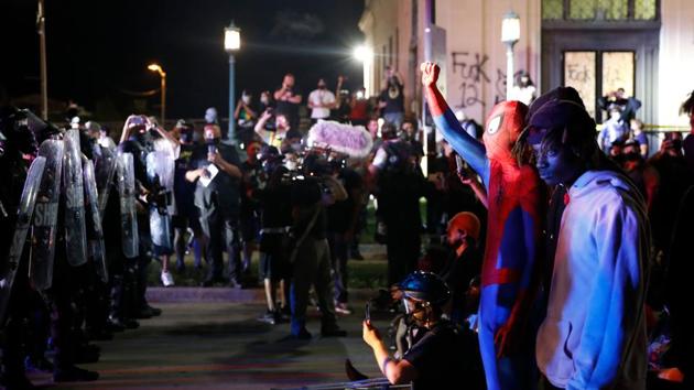 Protestors face off with police outside the County Courthouse during demonstrations against the shooting of Jacob Blake in Kenosha, Wisconsin on August 25. According to AP, police first fired tear gas during the protest on August 24, to disperse protesters who chanted, “No justice, no peace” as they confronted a line of officers who wore protective gear and stood shoulder-to-shoulder in front of the courthouse entrance in the post curfew hours. (Kamil Krzaczynski / AFP) Protestors face off with police outside the County Courthouse during demonstrations against the shooting of Jacob Blake in Kenosha, Wisconsin on August 25. According to AP, police first fired tear gas during the protest on August 24, to disperse protesters who chanted, “No justice, no peace” as they confronted a line of officers who wore protective gear and stood shoulder-to-shoulder in front of the courthouse entrance in the post curfew hours. (Kamil Krzaczynski / AFP)