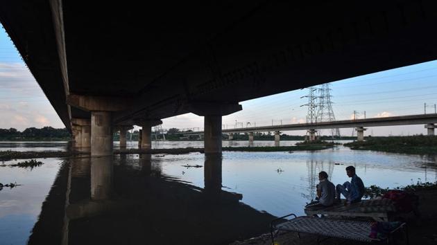 Men seen under a bridge along the swollen Yamuna river following heavy rain at Kashmere Gate in New Delhi on August 24. “We have identified locations for pitching tents. Besides, since social distancing is the norm during the Covid-19 pandemic, we have also identified schools where people can be moved with enough space to maintain physical distance,” Kumar told HT. (Sanchit Khanna / HT Photo)