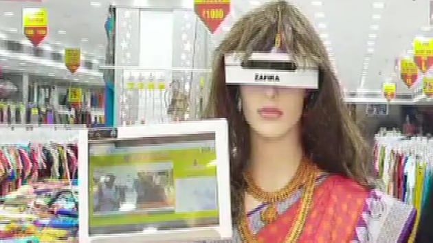 The saree-clad robot is scanning everyone entering the store for masks, checking their temperature and dispensing sanitiser. She is also keeping track on the number of people entering the store to avoid overcrowding.(ANI Twitter)