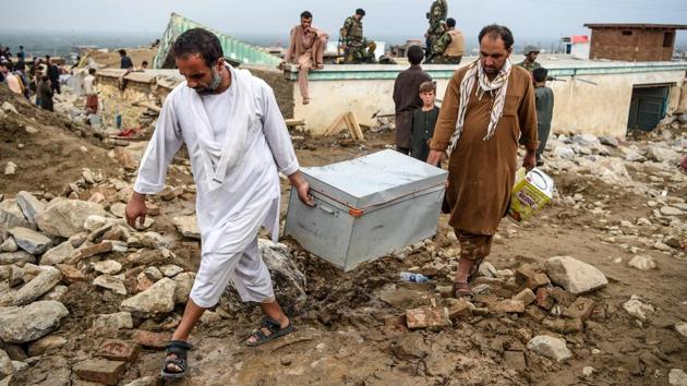 Survivors retrieve their belongings from the debris of their houses at Sayrah-e-Hopiyan in Charikar on August 26. Afghan authorities moved more than 900 families out of mountainous areas of Parwan province that were devastated by the flash floods. (Wakil Kohsar / AFP)