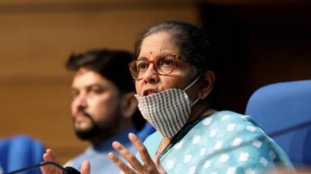 Nirmala Sitharaman, India's finance minister, wears a face mask as she speaks during a news conference in New Delhi. According to two government officials familiar with the matter, debt raised from market borrowings will be repaid from the compensation cess fund.(Bloomberg)