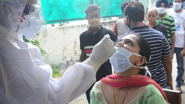 Patiala, India-August 27, 2020: A health worker in personal protective equipment (PPE) collects a swab sample from a woman for Covid-19 testing at CHC Model Town in Patiala, Punjab, India on Thursday, August 27, 2020. (Representational)(Bharat Bhushan / Hindustan Times)