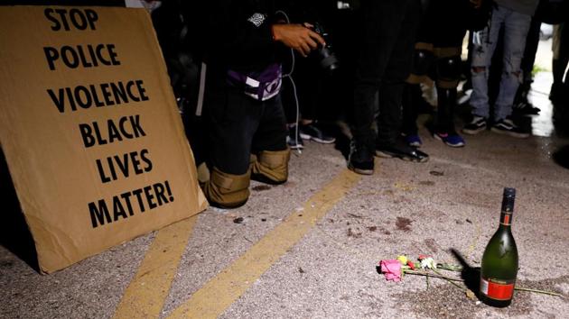 A sign is displayed as people pay tributes during a protest following the police shooting of Jacob Blake, in Kenosha, Wisconsin, on Wednesday.(Reuters Photo)
