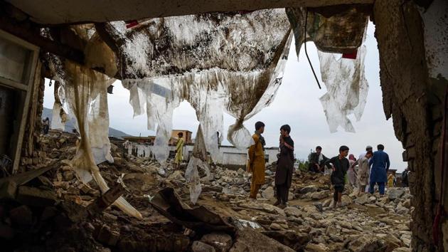 Villagers gather around the debris of their houses after a flash flood swept the area at Sayrah-e-Hopiyan in Charikar, Parwan province, Afghanistan on August 26. (Wakil Kohsar / AFP)