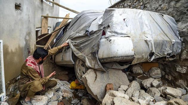 A villager inspects a damaged car among the debris of houses at Sayrah-e-Hopiyan in Charikar on August 26. At least 250 people were injured in the flash floods, Reuters reported. (Wakil Kohsar / AFP)