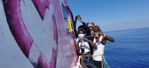 In this undated handout photo people pose for a photo after being rescued by the Louise Michel, a migrants search and rescue ship operating in the Mediterranean and financed by British street artist Banksy, at sea.  (via REUTERS) 