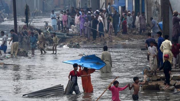 People evacuate a flooded residential area in Karachi on August 27 which marked the third day of heavy rains this week that have forced the residents to abandon their homes. (Asif Hassan / AFP) People evacuate a flooded residential area in Karachi on August 27 which marked the third day of heavy rains this week that have forced the residents to abandon their homes. (Asif Hassan / AFP)
