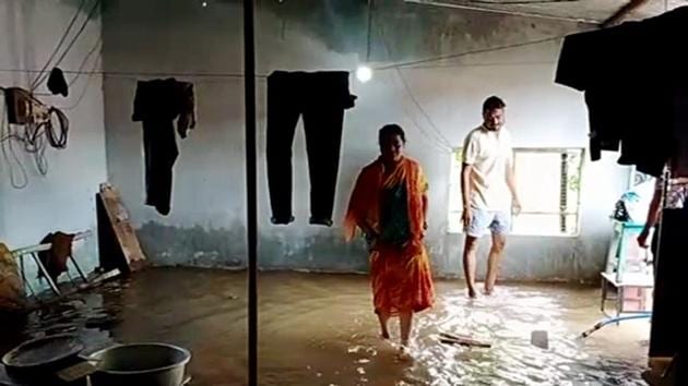 People are seen inside of their flooded house following heavy rainfall in the area.(ANI photo)