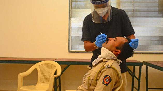 File photo: A Doctor takes a swab sample of a police personnel for Covid-19 testing at Navi Mumbai Police Headquarters at Roadpali in Kalamboli.(HT PHOTO)