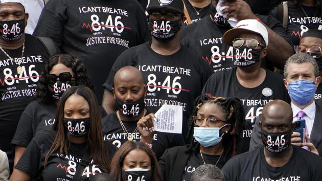 People wearing shirts to honor George Floyd watch at the March on Washington.(AP)