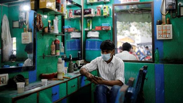A barber wearing a protective face mask looks at his mobile phone as he waits for customers in New Delhi on August 24. India also recorded its third day of cases over 75,000 with the addition of 76,472 new coronavirus cases on August 27. There were 75,760 new cases logged on August 27 and 77,266 on August 26. (Adnan Abidi / REUTERS) A barber wearing a protective face mask looks at his mobile phone as he waits for customers in New Delhi on August 24. India also recorded its third day of cases over 75,000 with the addition of 76,472 new coronavirus cases on August 27. There were 75,760 new cases logged on August 27 and 77,266 on August 26. (Adnan Abidi / REUTERS)