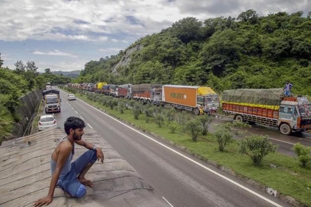 Stranded trucks wait for the opening of the Jammu-Srinagar national highway, on the outskirts of Jammu. Traffic is held up on the Jammu side due to the mudslide at Dalwas in Ramban district. National Highway Authority of India is working to restore traffic that has been held up since Tuesday.(PTI Photo)