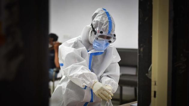 A health worker in PPE coveralls during collection of swab samples for coronavirus testing at a testing centre New Delhi.(Sanchit Khanna/HT PHOTO)