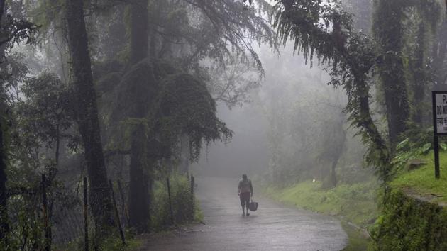 A man walks past a fog-covered street in Dharamsala on August 26.The western end of the monsoon trough – a band of low pressure -- is at its near normal position that stretches from Ganganagar to Bay of Bengal, while the eastern end is a south of its normal position. The western end is likely to shift northwards to the foothills of Himalayas in coming days. (Ashwini Bhatia / AP)