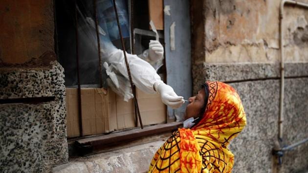 A health worker in personal protective equipment (PPE) collects a sample using a swab from a person at a local health centre.(REUTERS)