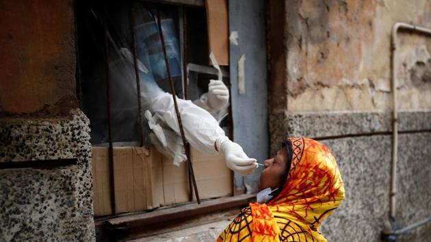 A health worker in personal protective equipment (PPE) collects a sample using a swab from a person at a local health centre to conduct tests for the coronavirus disease (COVID-19), amid the spread of the disease, in the old quarters of Delhi.(REUTERS)