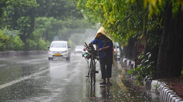 New Delhi, India - Aug. 19, 2020: A commuter pushes his cycle under rain near Adchini in New Delhi, India, on Wednesday, August 19, 2020. (Photo by Amal KS/ Hindustan Times)(Amal KS/HT PHOTO)