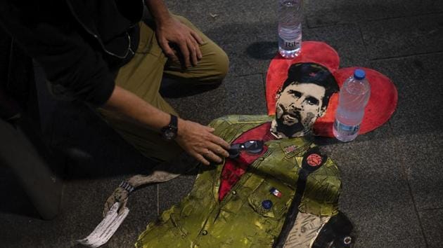 Artist TVBOY prepares to glue a painting depicting soccer player Lionel Messi dressed like Che Guevara named "Hasta Siempre Comandante", or "Until Forever Commander" in English, in Barcelona, Spain, Friday, Aug. 28, 2020. Messi has told Barcelona he wants to leave the club after nearly two decades with the Spanish giant. (AP Photo/Felipe Dana)(AP)