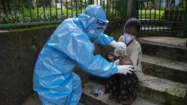 A health worker takes a nasal swab sample of a child to test for Covid-19 during a door to door test drive.(AP) A health worker takes a nasal swab sample of a child to test for Covid-19 during a door to door test drive.(AP)
