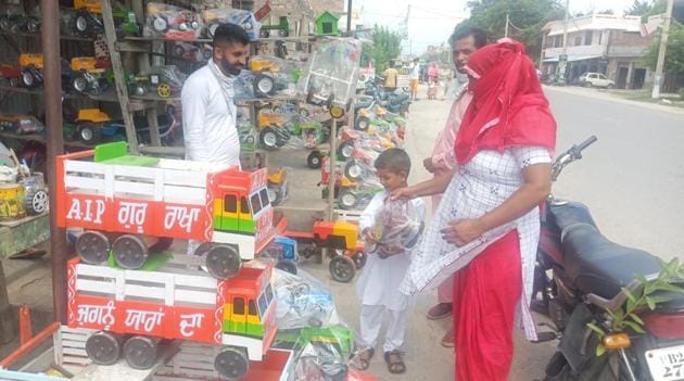 A shopkeeper shows a young customer and his parents a wooden tralla or truck.(HT photo)