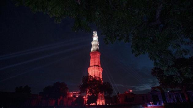 The image shows the Qutub Minar lit up in red and white lights against the night sky.(Twitter/@Adam_Burakowski)