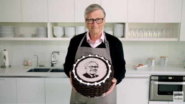 Bill Gates holding the special cake with Warren Buffett’s face on it.(YouTube/Bill Gates)