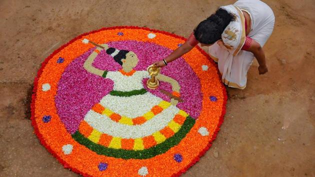 A Keralite woman makes 'Pookalam' (flower rangoli) on the occasion of Onam festival, Chikmagalur in Karnataka.(PTI)