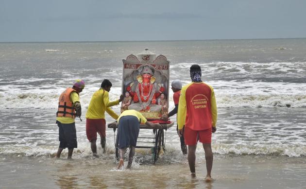 People carry and immerse the idols of Hindu God Ganesha on the last day of Ganpati Visarjan at Juhu Beach in Mumbai. (Satyabrata Tripathy/ht )