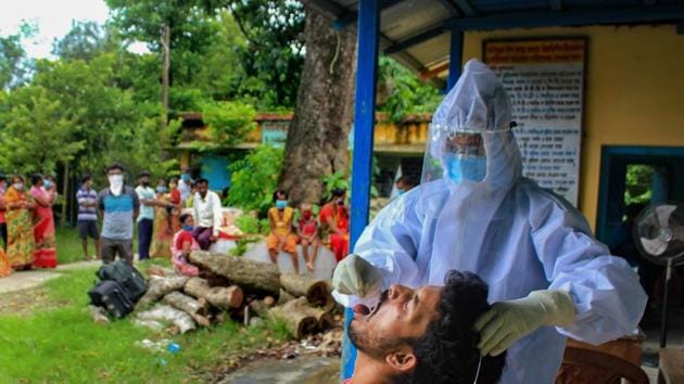 A health worker collects swab sample of a villager for Covid-19 test, in Manipur’s South Dinajpur district. (PTI) A health worker collects swab sample of a villager for Covid-19 test, in Manipur’s South Dinajpur district. (PTI)