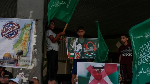 Palestinian demonstrators wave the green flag of the Hamas movement, carry pictures of Abu Dhabi's Crown Prince Sheikh Mohammed bin Zayed Al-Nahyan as well as banners with slogans against a US-brokered deal between Israel and the UAE to normalise relations, during a rally in the northern Gaza Strip refugee camp of Jabalia.(AFP) Palestinian demonstrators wave the green flag of the Hamas movement, carry pictures of Abu Dhabi's Crown Prince Sheikh Mohammed bin Zayed Al-Nahyan as well as banners with slogans against a US-brokered deal between Israel and the UAE to normalise relations, during a rally in the northern Gaza Strip refugee camp of Jabalia.(AFP)