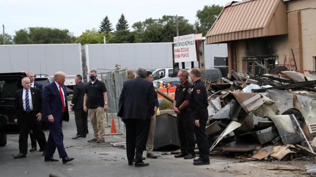 US President Donald Trump exits his motorcade to look at property damage in the aftermath of recent protests against police brutality and racial injustice and rioting after the shooting of Jacob Blake by a police officer in Kenosha.(REUTERS)