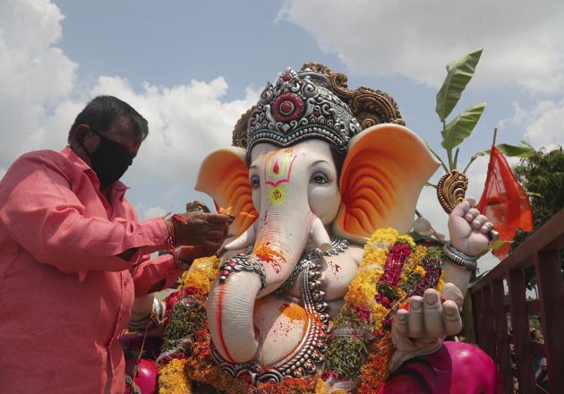 A devotee wearing a face mask as a precaution against the coronavirus offers prayers before immersing an idol of elephant-headed Hindu god Ganesha on the final day of Ganesh Chaturthi festival in Hyderabad, India, Tuesday, Sept. 1, 2020. The festival is a celebration of the birth of Ganesha, the Hindu god of wisdom, prosperity and good fortune. (AP Photo/Mahesh Kumar A.) (AP)