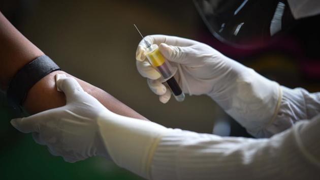 A healthcare worker collects a serological test sample, at a testing centre in Budh Vihar, New Delhi on Tuesday.(Sanchit Khanna/HT Photo)