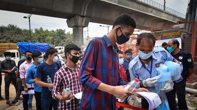 A security guard distributes masks to JEE Mains aspirants, queuing to enter the examination centre at Mundka in New Delhi on Wednesday. (Sanchit Khanna/HT PHOTO) A security guard distributes masks to JEE Mains aspirants, queuing to enter the examination centre at Mundka in New Delhi on Wednesday. (Sanchit Khanna/HT PHOTO)